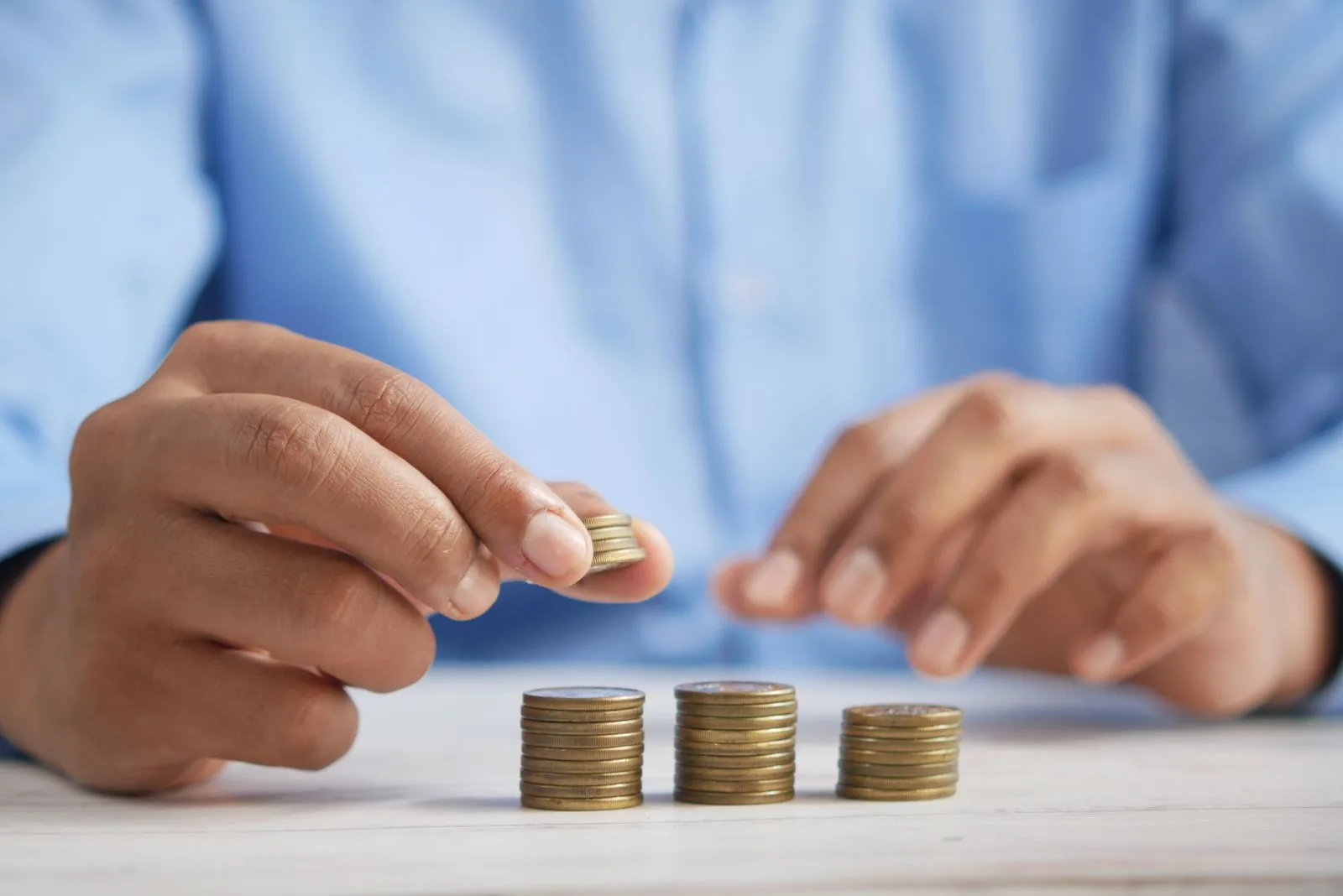 Hands stacking coins on a table