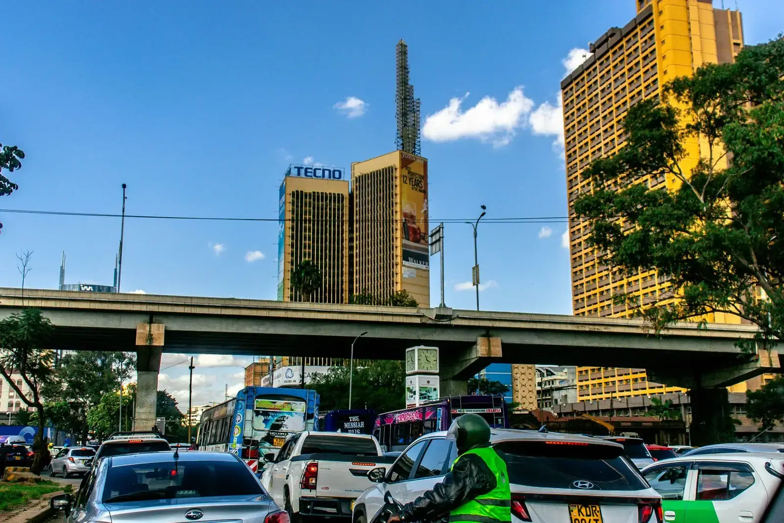 Traffic and tall buildings on a Nairobi street on a clear day